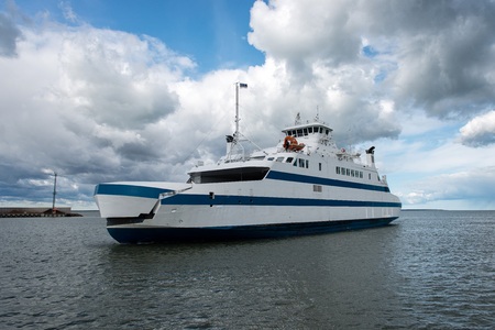 Water transport. Sunny day white ferry arrives quay.の写真素材