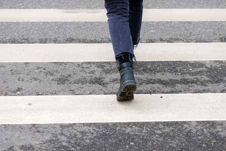Close-up of person crosses a pedestrian crossing back viewの写真素材