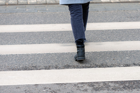Close-up of person crosses a pedestrian crossing back viewの写真素材