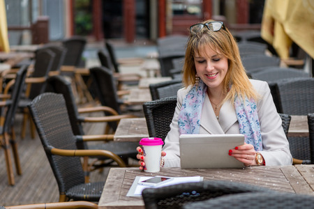 A young business woman drinking tea in a cafe and working with a computer. の写真素材