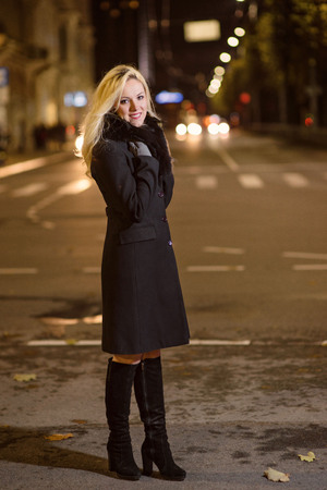 Beautiful, blonde woman in car lights in the night city.の写真素材