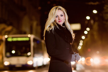Beautiful, blonde woman in car lights in the night city.の写真素材