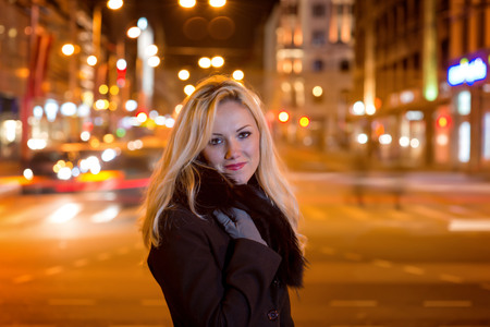 Beautiful, blonde woman in car lights in the night city.の写真素材