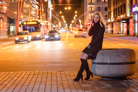 Beautiful, blonde woman in car lights in the night city.の写真素材