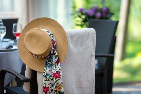 Chair with an Old Fashioned Womans Hat Hanging on it. の写真素材