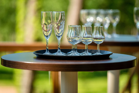 On the outdoor cafe table there is a tray with empty glass of wine.の写真素材