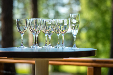 On the outdoor cafe table there is a tray with empty glass of wine.の写真素材