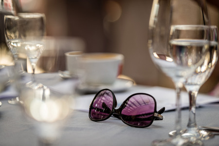 Close-up selective focus photography. On the table are sunglasses and wine glasses.の写真素材