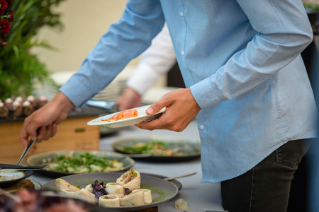 People at a banquet taking different food. Colleagues Buffet Party Brunch Dinning Conceptの写真素材