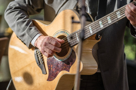Closeup of man's hands playing acoustic guitar. Musical concept.の写真素材