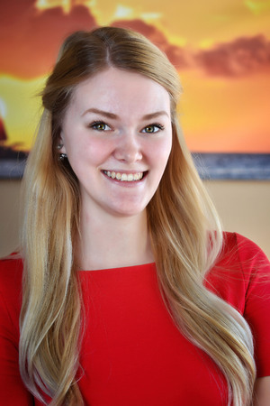 Smiling blonde woman in red dress.の写真素材