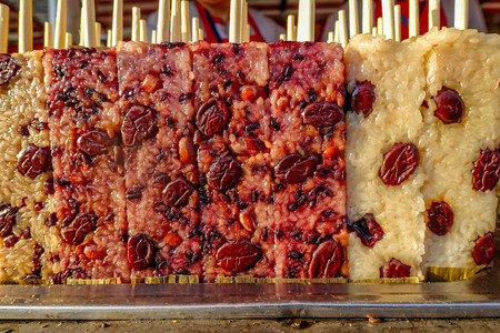 Snack Street in Beijing China. Famous Beijing street food glutinous rice stick, cooked rectangle purple rice cake.の写真素材