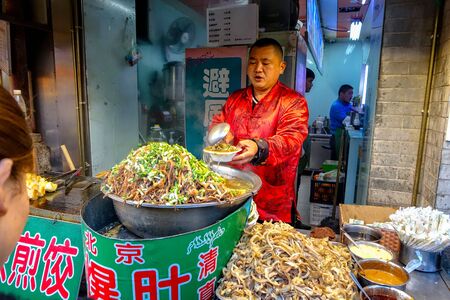 BEIJING, CHINA - MARCH 11, 2016: Food vendors offers its products at the Donghuamen Night Market near Wangfujing Street in Beijing, Chinaのeditorial素材