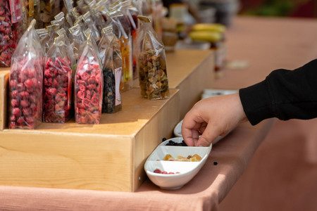 The buyer will take candy from the bowl of sweets tasting samples.の写真素材