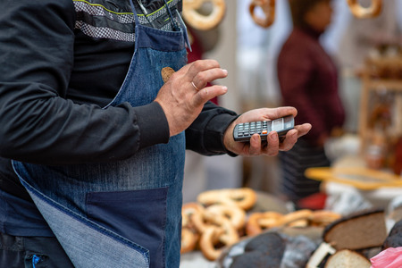 The seller calculates the price of the product with a calculator.の写真素材