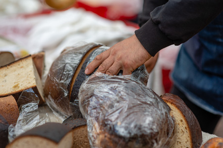 A baker with a knife cuts a big bribe.の写真素材