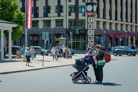 RIGA, LATVIA - JUNE 22, 2018: Tourists with a baby carriage and large backpacks view the city.