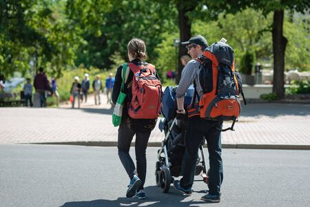 RIGA, LATVIA - JUNE 22, 2018: Tourists with a baby carriage and large backpacks view the city.