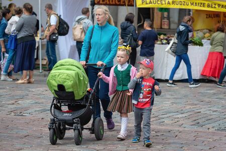 RIGA, LATVIA - JUNE 22, 2018: Summer solstice market. Family with children walking on the market.のeditorial素材