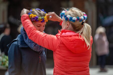 RIGA, LATVIA - JUNE 22, 2018: Summer solstice market. Woman puts on his head a crown of flowers.