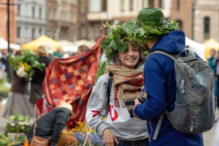 RIGA, LATVIA - JUNE 22, 2018: Summer solstice market. A smiling young woman staring at her boyfriend...