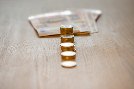 Selective focus photograph. Stack with 1 euro coins and banknotes in the background.の写真素材