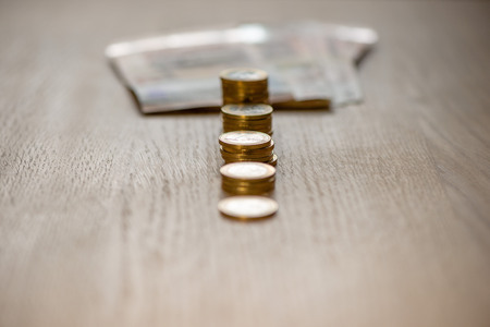 Selective focus photograph. Stack with 1 euro coins and banknotes in the background.の写真素材