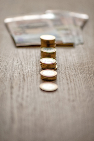 Selective focus photograph. Stack with 1 euro coins and banknotes in the background.の写真素材