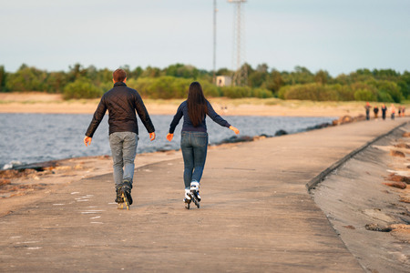A couple of young people walking on the roll with roller skates.の写真素材