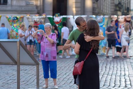 RIGA, LATVIA - JULY 26, 2018: United Buddy Bears exhibition. City residents and tourists are looking at and photographing the exhibition at the Old Town square. A couple of young people will kiss in front of all people.のeditorial素材