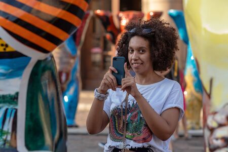 RIGA, LATVIA - JULY 26, 2018: United Buddy Bears exhibition. A woman with a phone takes pictures of...