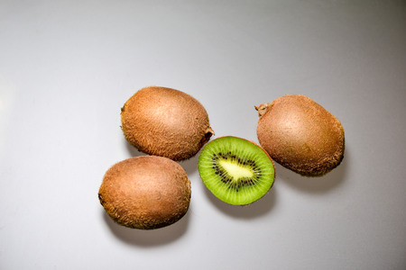 Ripe whole kiwi fruit and half kiwi fruit isolated on gray backgroundの写真素材