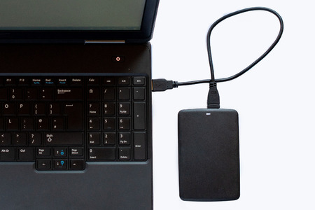 A portable computer and a USB drive on a white background.の写真素材