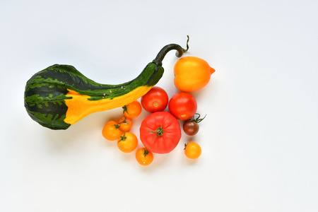 Pumpkin and red, yellow tomatoes on a white background.の写真素材