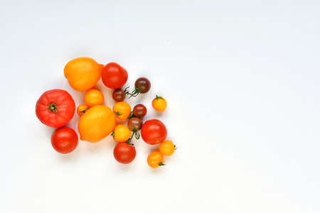 Autumn harvest. Red and yellow tomatoes on a white background.の写真素材