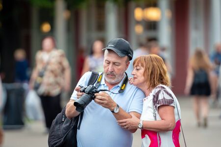 RIGA, LATVIA - AUGUST 18, 2018: Tourists are watching pictures in the camera