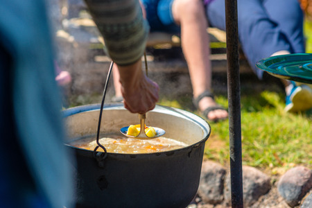 Cooking food in a pot on campfire. Summer camping concept.の写真素材