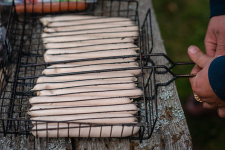 Sausages are prepared for cooking on the grill.の写真素材