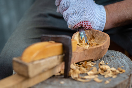 Craftsman demonstrates the process of making wooden spoons handmade using tools. National crafts concept.の写真素材