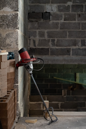 Electric drill with a mixer in a newly constructed building.の写真素材
