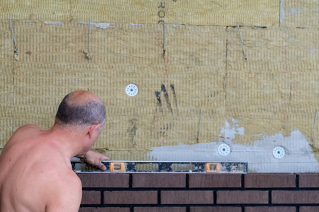 Bricklayer worker installing bricks on construction site.の写真素材