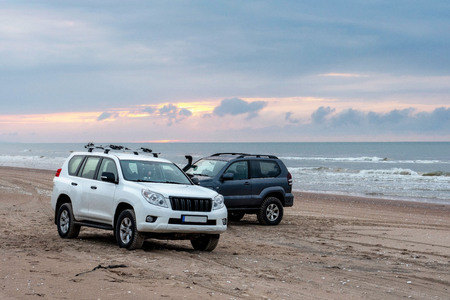 Two 4x4 jeeps on the seashore during the sunset.の写真素材