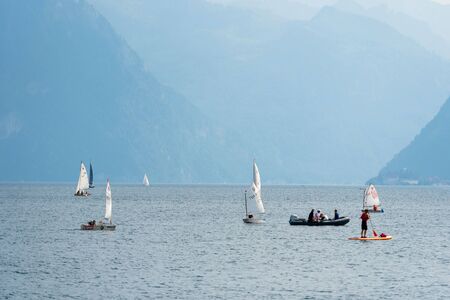 GMUNDEN, AUSTRIA, - AUGUST 03, 2018: Blue water lake landscape with boots. Traunsee. Mountain background.のeditorial素材