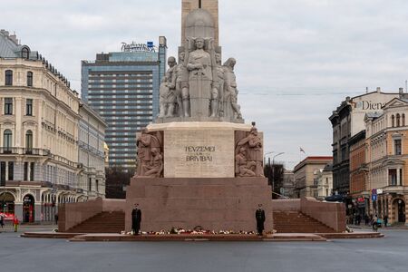 RIGA, LATVIA - NOVEMBER 14, 2018: Latvia 100 years. Soldiers guard of honor at the Freedom Monument. The inscription on the monument to Latvian FATHERLAND AND FREEDOMのeditorial素材