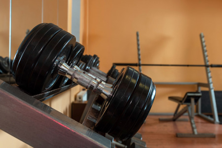 Rows of metal dumbbells on rack in the gym / sport club. Weight Training Equipment. - Imageの写真素材