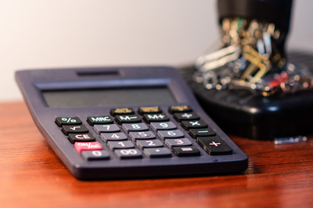 Office desk with calculator and paper clips in the background - imageの写真素材