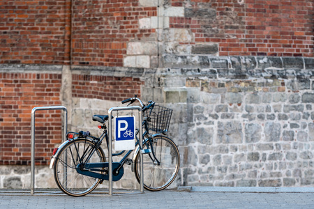 The bicycle is parked on the parking lot at the edge of the old town street.の写真素材
