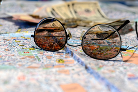Sunglasses and money on a tourist map background. Tourism concept.の写真素材