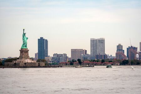 New York, USA - June 7, 2019: Statue of Liberty, Liberty Island, with Manhtattan in the background -...