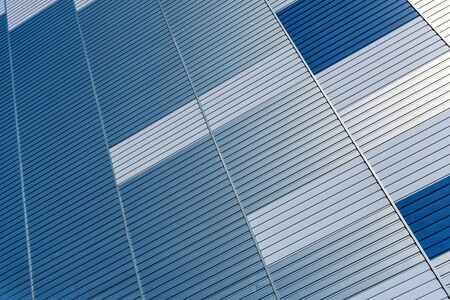 Abstract architectural background from modern buildings facade with blue and silver lines - image